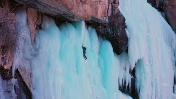 Ice Climbing Frozen Waterfall Aerial View Man Placing Ice Screw — Stock video