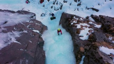 Donmuş Şelaleye Buz Tırmanışı, Havadan Yukarıdan Aşağı Görünümü. Kadın buz vidası yerleştiriyor. Barskoon Vadisi, Kırgızistan