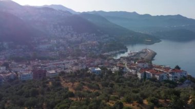 White Houses of Kas Town, Sea and Mountains on Sunny Day. Antalya, Turkey. Aerial View. Drone Flies Backwards and Upwards