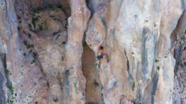 Man Climber Rock Climbing in Helmet. Cliffs of Geyikbayiri, Antalya, Turkey. Aerial Shot Orbiting