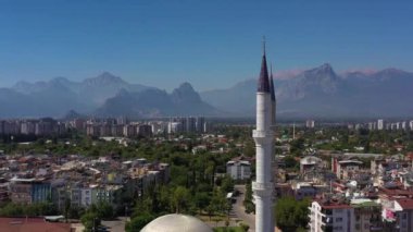 Minarets of Mosque, Cityscape and Mountains. Antalya Turkey. Aerial View. Drone Flies Upwards, Tilt Down. Crane Shot