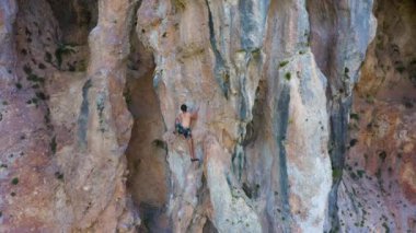 Man Climber Rock Climbing. Antalya, Turkey. Aerial View. Drone Flies Upwards, Tilt Down. Crane Shot