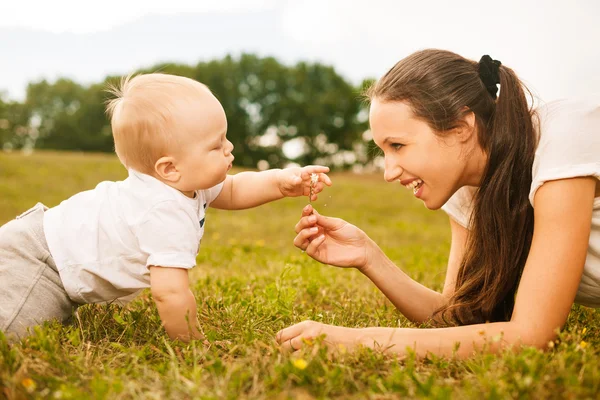 Mooie jonge moeder bloem te geven aan haar baby — Stockfoto