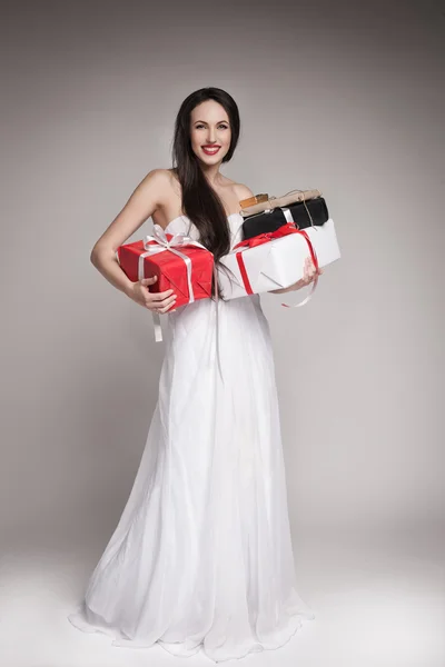 Sonriente hermosa mujer sosteniendo regalos — Foto de Stock