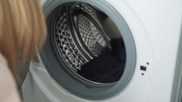 Nő betöltése piszkos színes lóhere mosógép — Stock videók