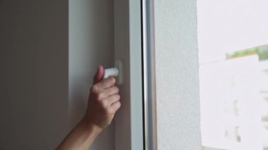 Kadın temiz havaya açılan pencereyi açar