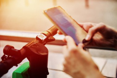 Kadın akıllı telefon uygulaması ile elektrikli scooter 'ın kilidini açıyor.
