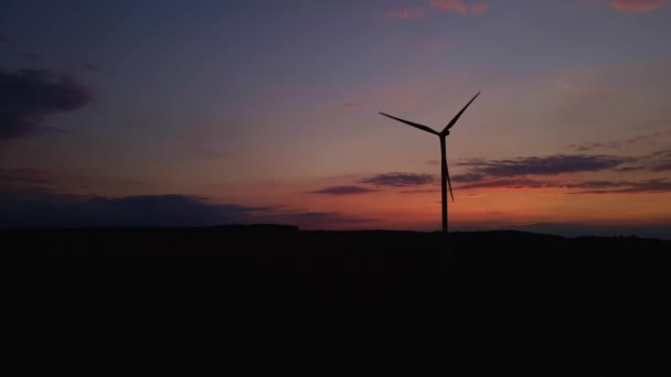 Silhouette de turbine éolienne dans le champ au coucher du soleil. Générateur éolien rotatif — Video