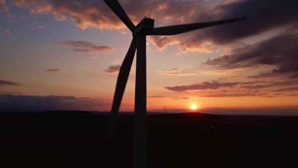 Silhouet van windmolen turbine in het veld bij zonsondergang hemel. Roterende windgenerator — Stockvideo
