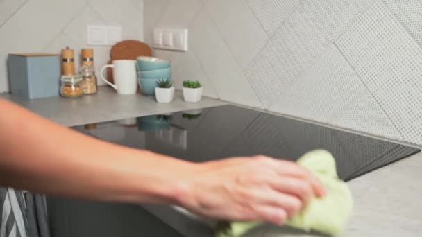 Kobieta w gumowych rękawiczkach do czyszczenia indukcyjnego pieca — Wideo stockowe