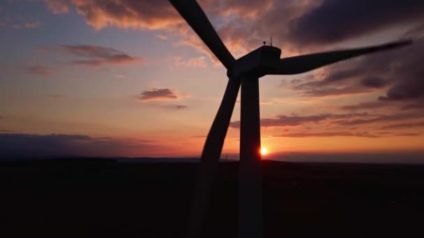 Silhueta de turbina de moinho de vento no campo ao pôr do sol céu. Gerador de vento rotativo — Vídeo de Stock