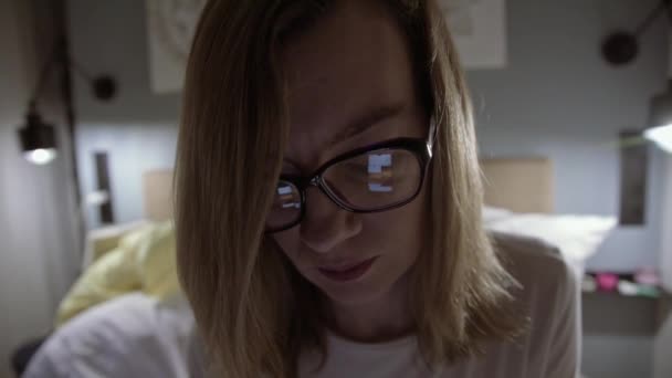 Женщина в очках ночью пользуется смартфоном — стоковое видео