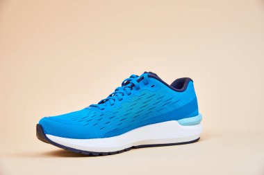 Bej arka planda mavi koşu ayakkabısı, kapat