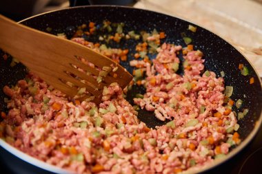 Kadın mutfakta bolonez sosu pişiriyor.