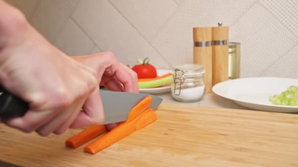 Mulher cortando cenoura na cozinha, close — Vídeo de Stock