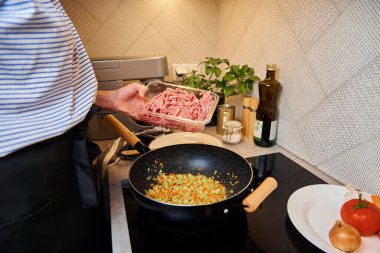 Kadın mutfakta bolonez sosu pişiriyor.