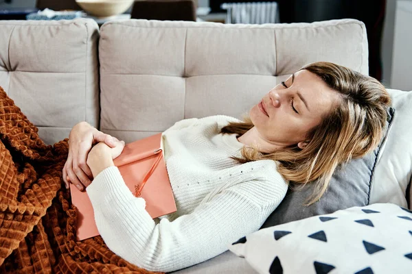 Mujer duerme en sofá con libro — Foto de Stock