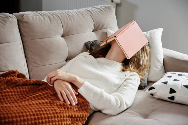 Mulher dorme no sofá com livro — Fotografia de Stock