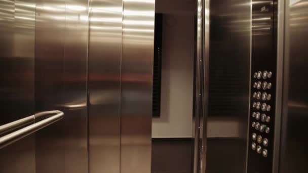 Двери лифта открыты, и женщина выходит — стоковое видео