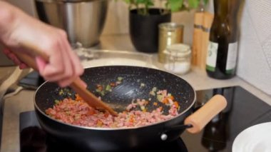 Kadın mutfakta bolonez sosu pişiriyor.
