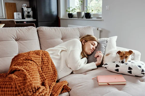 Kvinna sover med hund på soffan — Stockfoto