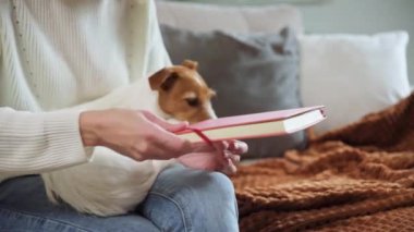 Kadın evde deftere notlar yazıyor.