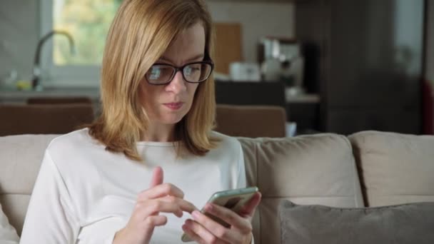 Žena pomocí smartphonu v obývacím pokoji — Stock video