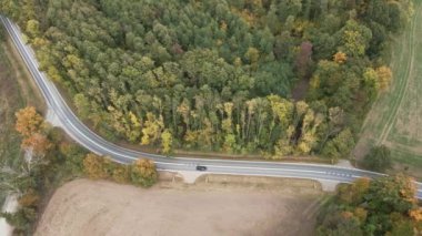Araba kırsal asfalt yolda gidiyor, hava manzaralı.
