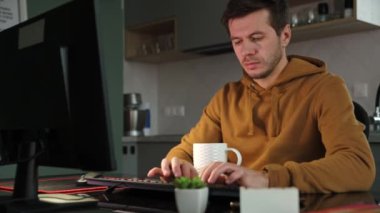 Adam ev ofisinde uzaktan bilgisayar kullanarak çalışıyor.