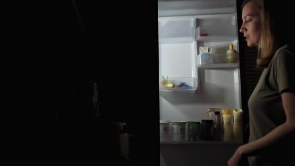 Mujer tomar manzana del refrigerador por la noche — Vídeo de stock