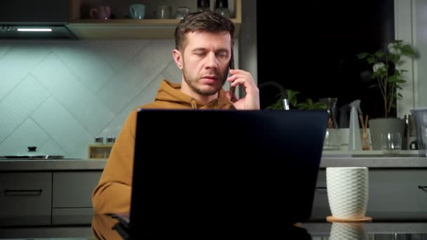 Чоловік говорить смартфон в домашньому офісі — стокове відео
