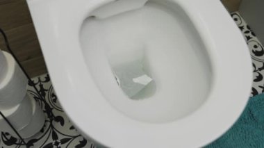 Tuvalet kağıdı klozete düşer ve sifonu çeker.