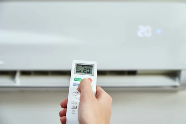 Hand adjusting temperature on air conditioner — Foto Stock