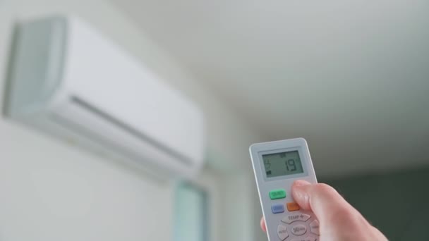 Hand adjusting temperature on air conditioner — Stockvideo