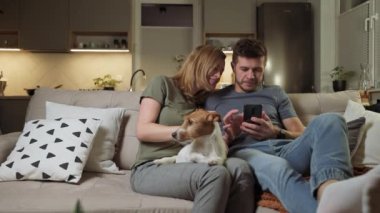 Oturma odasında akıllı telefon kullanan çift.