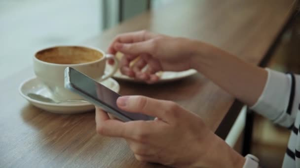 A nő a kávézóban reggelizik, okostelefont használ a kávézóban — Stock videók