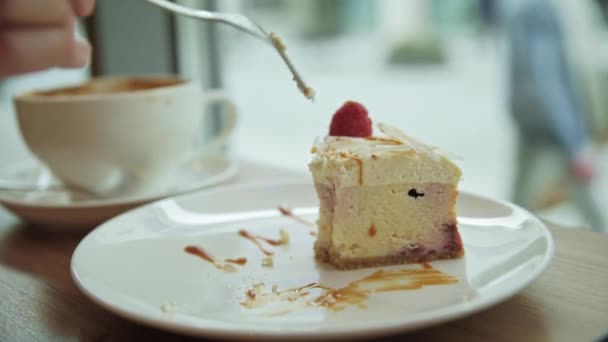 Kvinna äter frukost på caféet, äter hallon cheesecake med kaffe — Stockvideo