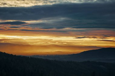 Dağların üzerinde gün batımı dramatik gökyüzü