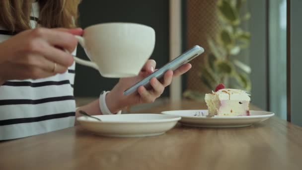 女性はカフェで朝食を食べ、カフェでスマートフォンを使う — ストック動画