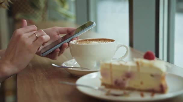 Vrouw ontbijten in café, smartphone gebruiken in café — Stockvideo