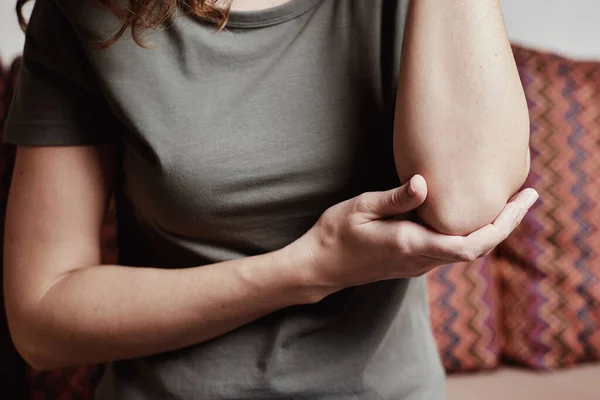 Женщина имеет боль в локте, трогательная рука — стоковое фото