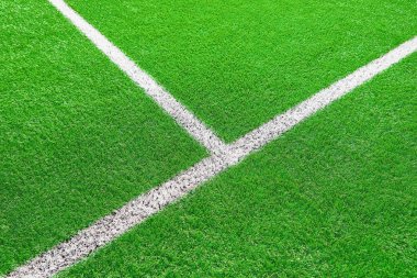 Futbol ya da futbol sahasının bir kısmı kapalı, beyaz sınır çizgileri olan sanatsal yeşil çimenler, kıvılcım oyunları için stadyumda Astroturf