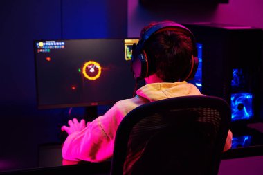 Genç çocuk karanlık odada bilgisayar oyunu oynuyor, neon renkli rgb mekanik klavye kullanın, siber spor oyunları için yer