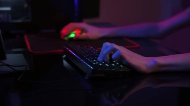 Profesyonel oyuncu karanlık odada bilgisayar oyunu oynar, neon renkli rgb mekanik klavye kullanın, siber spor oyunları için yer