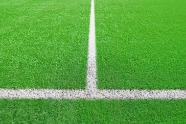 Futbol ya da futbol sahasının bir kısmı kapalı, beyaz sınır çizgileri olan sanatsal yeşil çimenler, kıvılcım oyunları için stadyumda Astroturf