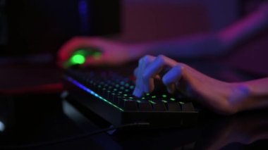 Profesyonel oyuncu karanlık odada bilgisayar oyunu oynar, neon renkli rgb mekanik klavye kullanın, siber spor oyunları için yer