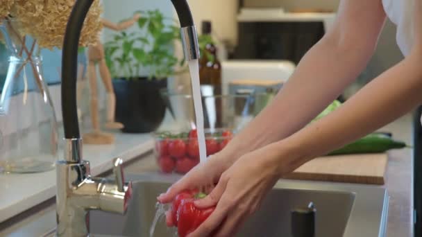 Mulher lavando legumes na pia da cozinha — Vídeo de Stock