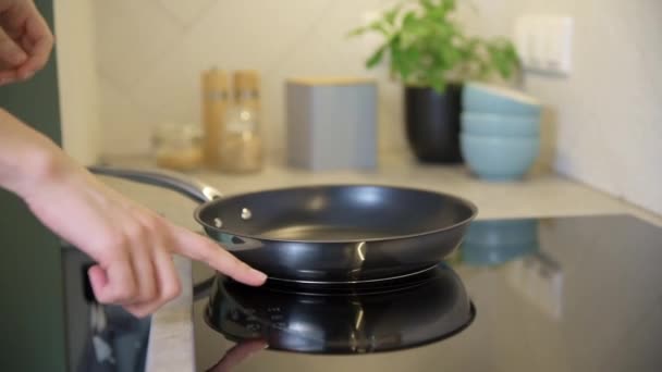Γυναικείο χέρι ανάβει μοντέρνα επαγωγική σόμπα στην κουζίνα — Αρχείο Βίντεο