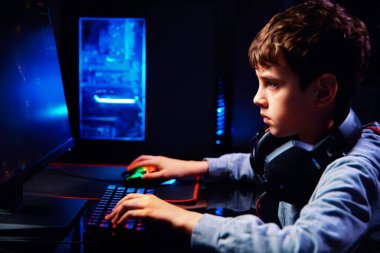 Genç çocuk karanlık odada bilgisayar oyunu oynuyor, neon renkli rgb mekanik klavye, siber spor oyunları için iş yeri, oyun bağımlılığı