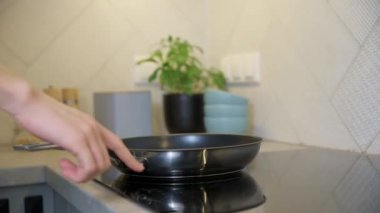 Modern mutfak aletleri. Kadın eli yemek pişirmek için indüksiyon sobasını açıyor. İndüksiyon ya da elektrik hobisinde parmak sensör düğmesine bas